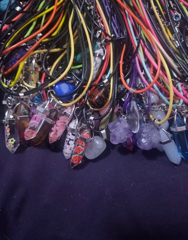 a bunch of different colored cords and stone pendants