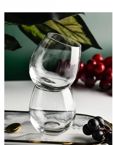a glass of wine on a tray with grapes and grapes