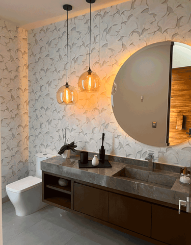  Baño moderno con lavabo de mármol, espejo circular e iluminación cálida KARÄNA