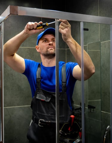 Plumer fixing a shower door in Auckland