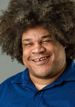 A picture of David, a Black man wearing a blue polo shirt