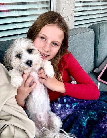 a girl is holding a puppy in her arms