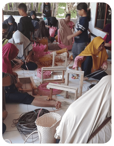 Artisans finishing colorful jali jali plastic woven bags by hand at Craftvitas Indonesia workshop.