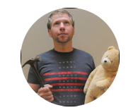 a man looking up holding a hammer and a teddy bear