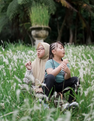 Sister and child sharing a quiet moment in an alang alang field during a Bedugul family photography session.