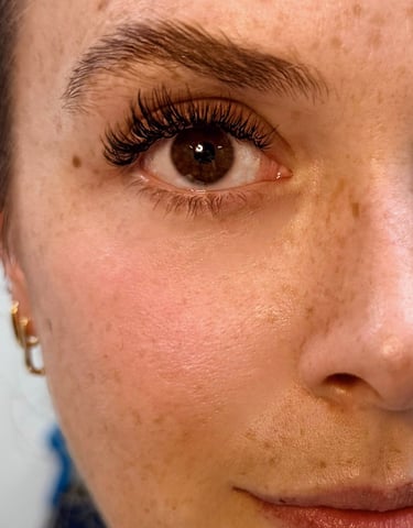 Close-up of wispy lash extensions over open fans, in Bird Rock