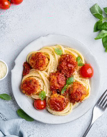 spaghetti with meatballs and cherry tomatoes and parmesan cheese 