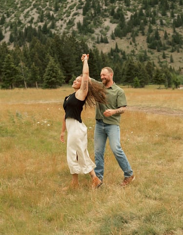 a man and woman are playing with a kite