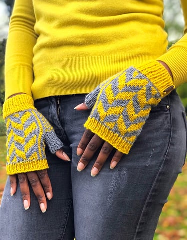 a woman in a yellow sweater wearing a pair of yellow and grey fingerless knitted mittens