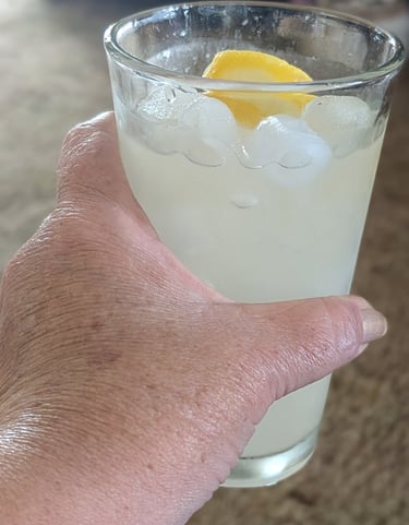 woman holding a glass of lemonade representing peaceful simple life after 50
