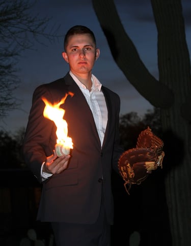 Young man holding a baseball mitt and baseball. The baseball is on fire! Cactus in the background.