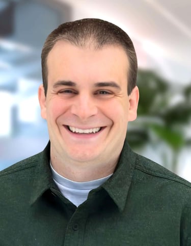 a man in a green shirt smiling at the camera
