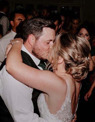a bride and groom kissing on the dance floor