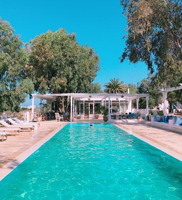 a pool with lounge chairs and a swimming pool
