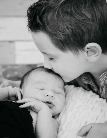 rand frère embrassant bébé sur le front – photo noir et blanc, naissance Gard