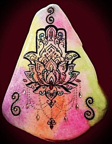 A painted rock with a Hamsa Tattoo.