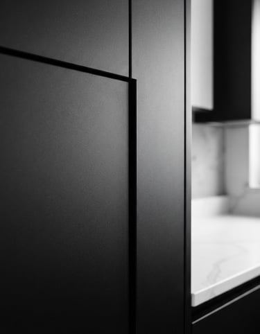 Close-up architectural photography of a perfectly aligned matte black kitchen cabinet joint, crisp natural light, high-contrast neutral tones, sharp focus