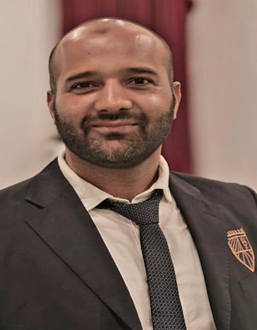 a man in a suit and tie with a badge on his chest