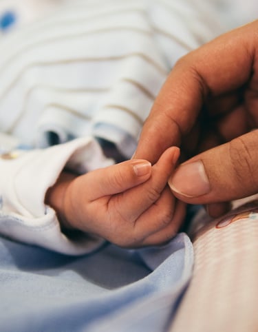 Main d'une maman qui tient la main d'un bébé