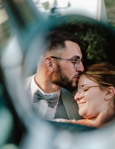 Mariés qui s'embrassent dans le reflet du rétroviseur
