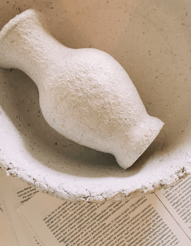 a white ceramic bird in a bowl on a table