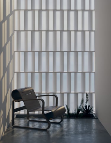 Sunlit reading nook with a sculptural black lounge chair and textured privacy screen