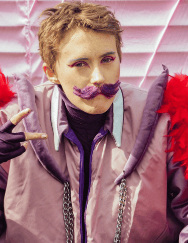 a woman with a purple jacket and red feathers