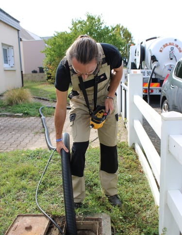 un artisan vidangeur pompant une fosse septique