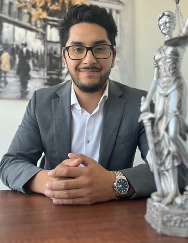 a man in a suit and glasses sitting at a table