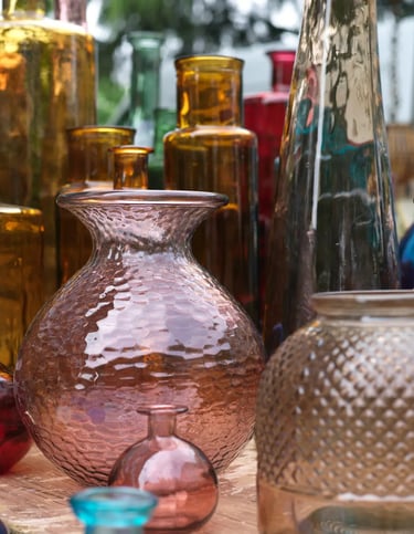 vases jaunes et roses de différentes formes et tailles sur un étal dans un marché aux puces