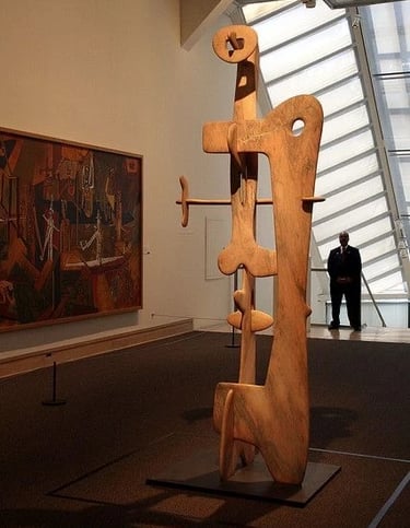 Large wooden Isamu Noguchi sculpture displayed in a museum space with warm natural material and orga