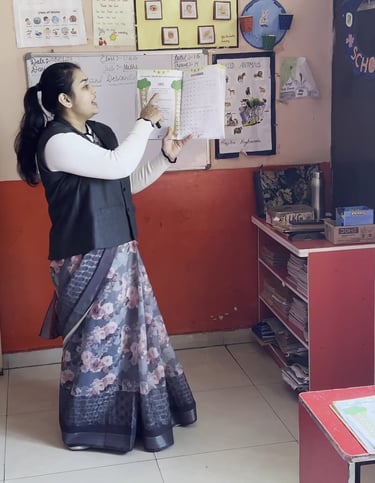 A teacher in a classroom holding up a textbook to teach elementary students.