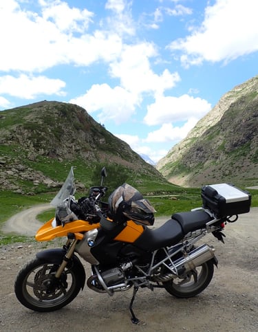 a motorcycle parked on a dirt road near a mountain