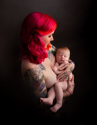 tattooed redhead woman carrying a baby