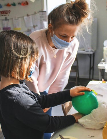 Young teen helping a youth student with her project.