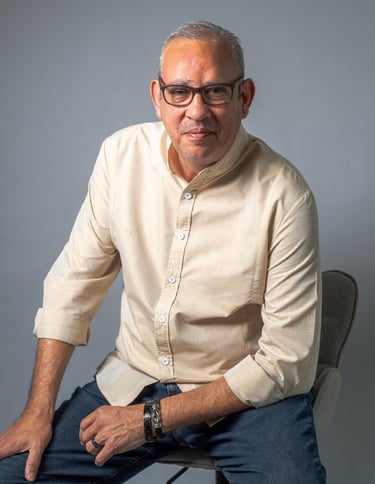 Portrait of a man in a white shirt and jeans sitting on a chair, photo studio en Jaco Costa Rica