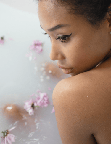 a young girl in a bathtub with flowers