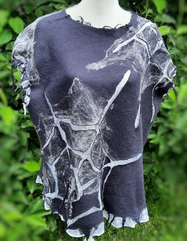 Handmade nuno felted wool tunic in charcoal gray with white web design on a dress form.
