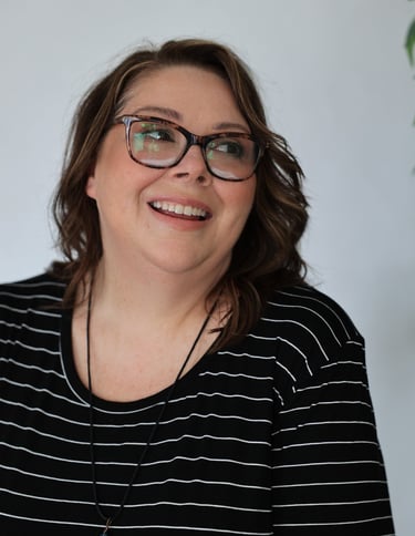 a woman with glasses and a necklace with a blue necklace
