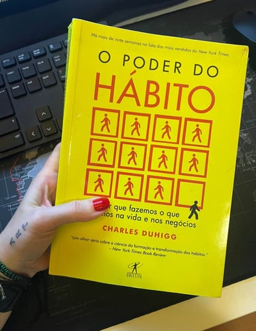 Portuguese edition of the book The Power of Habit by Charles Duhigg with a yellow cover and red icons.