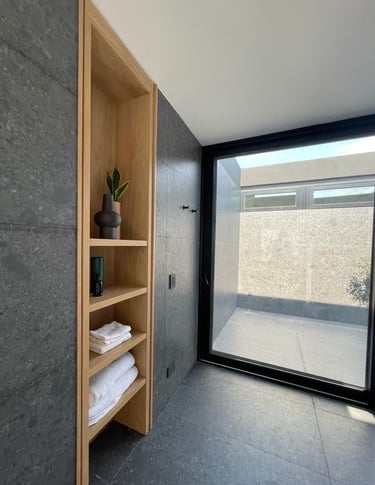 a bathroom with a shelf with towels and towels