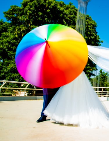 sposi che si divertono con un coloratissimo ombrello