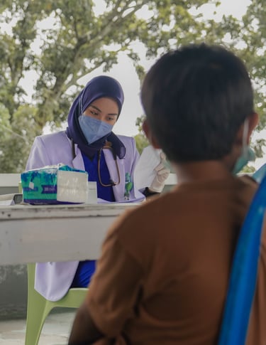Dokter wanita berjilbab dan bermasker memberikan konsultasi kesehatan kepada anak di area terbuka