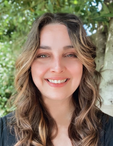 a portrait of shannon, and woman with long hair and wearing a black shirt. Tree background