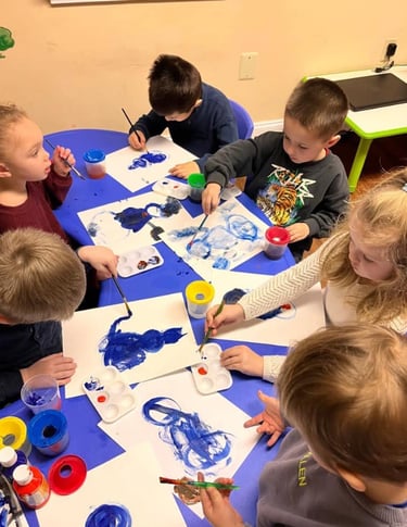 Children painting with guidance at Kids Land Daycare, Warminster
