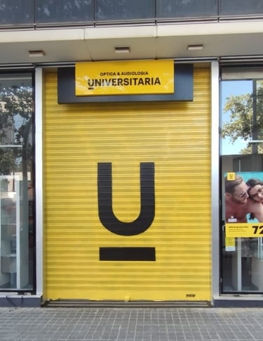 Graffiti en persiana, cierre metálico de Óptica Universitaria, Barcelona