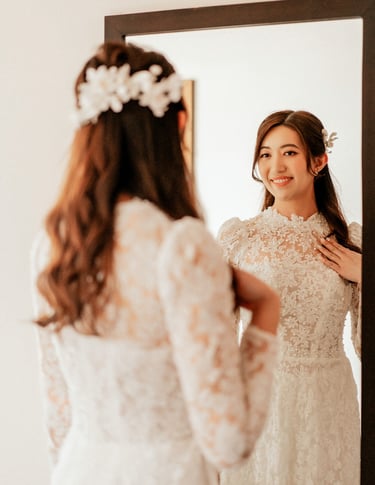 a woman in a wedding dress is looking at herself in the mirror