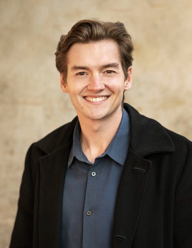 a man in a black jacket and a blue shirt