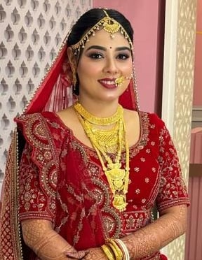 Indian bride in traditional red lehenga with HD bridal makeup, multi-layered gold jewelry, mehendi, 