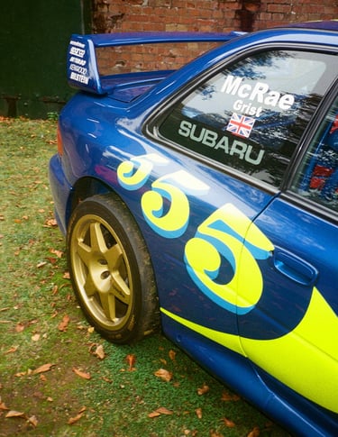 a blue and yellow Subaru Impreza rally car